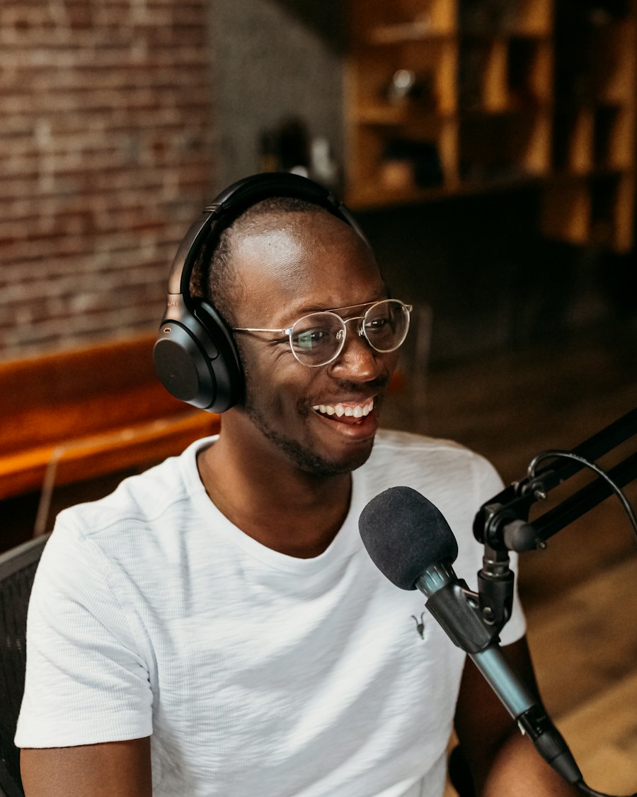 Smiling man wearing headphones in front of a microphone